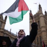 People waving Palestinian flags during a rally calling for a ceasefire outside parliament in February. Photo: PA